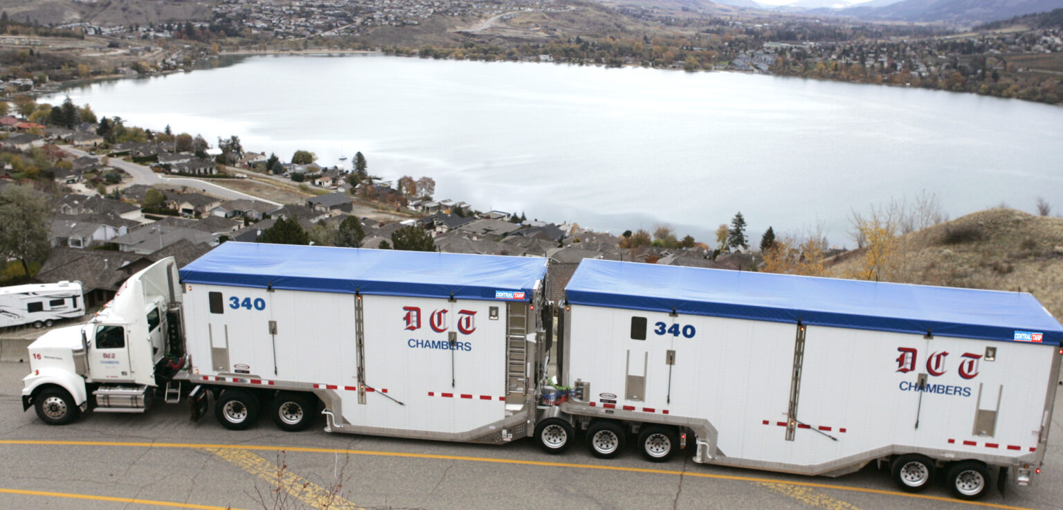 Truck with tarp on it driving along lake